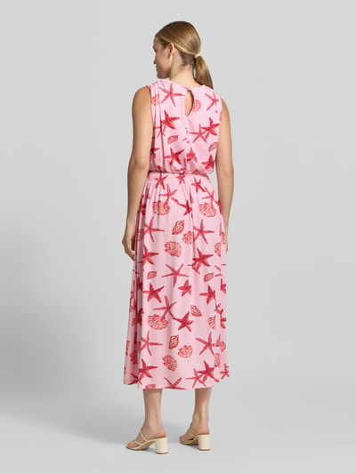 Frauenmodel trägt Midikleid mit Allover-Motiv-Print von Milano Italy in Rosa mit Rot, Tailliert, V-Ausschnitt, Smok-Detail, Ganzkörperansicht Rückansicht. Rückenlänge bei Größe S: 117 cm, Ärmellänge bei Größe S: 47 cm.