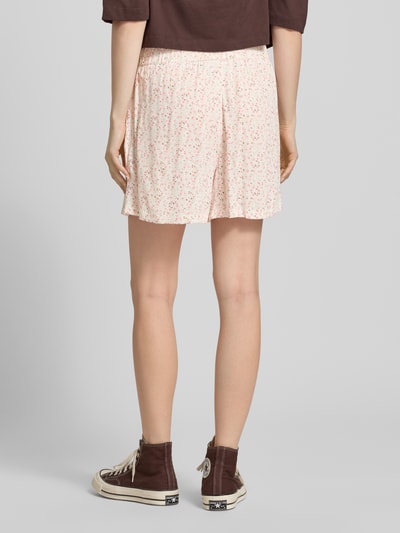 Frauenmodel trägt Regular Fit Shorts aus reiner Viskose Modell 'BARRI' von Pieces mit Florales-Allover-Muster und seitlichen Eingrifftaschen, Ganzkörperansicht Rückansicht.
