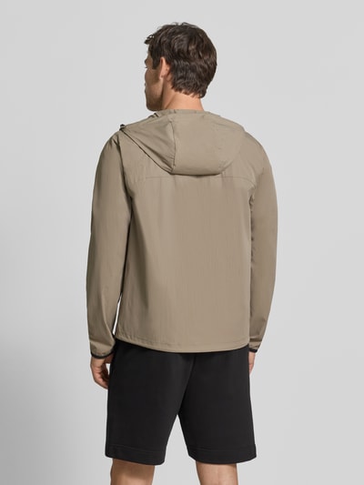 Männermodel trägt Regular Fit Trainingsjacke mit Label-Print Modell 'OW_Airynix JT HD 2' von BOSS Green in Beige, glatte Struktur, Ganzkörperansicht Rückansicht.