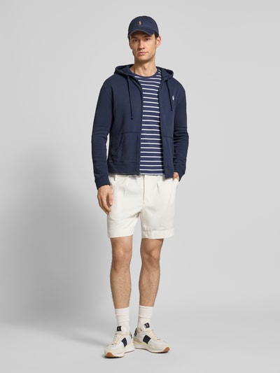 Męski model nosi Regular Fit Sweatjacke aus Baumwoll-Mix od Polo Ralph Lauren, efekt: jednolity kolor, długi rękaw, kaptur z tunelem, zamek błyskawiczny, wyhaftowane logo, mieszanka bawełny, dzianina dresowa, Ganzkörperansicht von vorne.