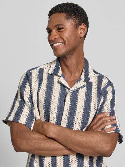 Männermodel trägt Modern Fit Freizeithemd mit Reverskragen von Lindbergh, gestreiftes Muster in Blau und Beige, Nahaufnahme Oberkörper. Material-Mix mit Viskose-Anteil, Knopfleiste erkennbar.