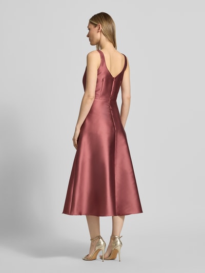 Frauenmodel trägt Cocktailkleid mit Karree-Ausschnitt von Swing, taillierte Passform, Midikleid, Rückenreißverschluss, Rückenlänge 125 cm, Brustweite 34 cm, seidig glänzende Textur in Altrosa, Ganzkörperansicht Rückansicht.