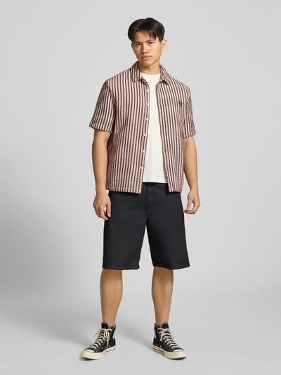 Männermodel trägt Regular Fit Freizeithemd mit Streifenmuster von REVIEW aus reiner Baumwolle, Kentkragen, Knopfleiste, schwarz-weiß-rot, strukturiert, 1/2-Arm, Logo-Stitching, Ganzkörperansicht von vorne.