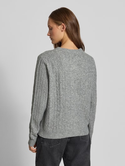 Frauenmodel trägt Regular Fit Strickjacke mit Woll-Anteil Modell 'SILLY' von PIECES in Grau, dezente Zopfmuster, Damen Strickjacke, Ganzkörperansicht Rückansicht