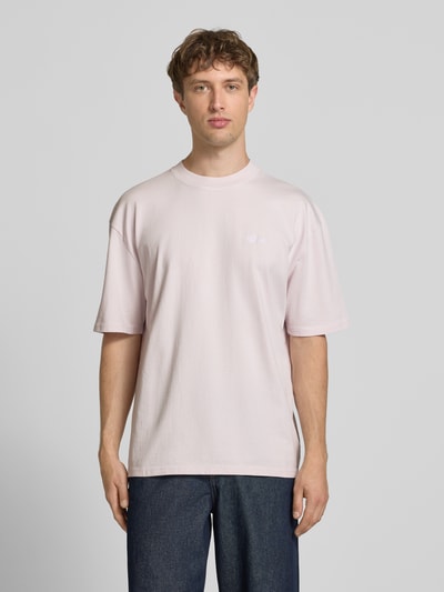 Männermodel trägt Oversized T-Shirt mit Label-Stitching von Pegador, Herren T-Shirt aus Reine Baumwolle, Rundhalsausschnitt, gerade Formen, helle Farbe, Rückenlänge 70 cm bei Größe M, Ganzkörperansicht von vorne.