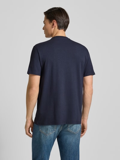 Männermodel trägt dunkelblaues T-Shirt mit Logo und Rundhalsausschnitt von Guess, Relaxed Fit, Baumwoll-Mix, Rückansicht Ganzkörperansicht.
