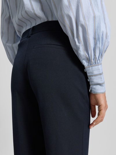 Männermodel trägt spodnie materiałowe 'Stoffhose mit weitem Bein und Bügelfalten' von Christian Berg Woman Selection, mieszanka materiałów z dodatkiem wiskozy, szerokie nogawki, kanty, tylna, lamowana kieszeń, szerokość w rozmiarze 36: 40 cm, długość wewnętrzna nogawki w rozmiarze 36: 84 cm, zdjęcie detaliczne z tyłu.