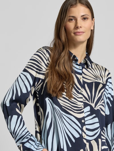 Frauenmodel trägt Regular Fit Hemdbluse aus reiner Viskose von s.Oliver BLACK LABEL, wzór na całej powierzchni, krój regular fit, kołnierzyk koszulowy, wielokolorowe wzory, kontrafałda, listwa guzikowa, długie rękawy z mankietem, lekko zaokrąglone wykończenie, satynowa powierzchnia, materiał: czysta wiskoza, Nahaufnahme Oberkörper.