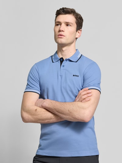 Männermodel trägt Slim Fit Poloshirt aus reiner Baumwolle Modell 'PAUL' von BOSS Green, Optik: Unifarben, Ganzkörperansicht von vorne.