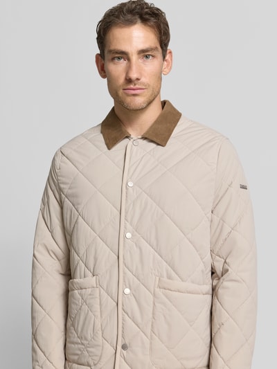 Männermodel trägt gewatteerd jack met contrasterende platte kraag, drukknoopsluiting, opgestikte steekzakken, elastische materiaalmix, recht pasvorm, cinqe, Nahaufnahme Oberkörper. Ruglengte maat M: 76 cm, schouderbreedte: 44 cm, borstwijdte: 57 cm, mouwlengte: 66 cm.