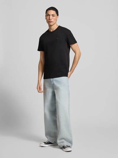 Männermodel trägt Regular Fit T-Shirt aus reiner Baumwolle von Tommy Jeans, Optik: Unifarben, Logo-Detail, Rundhals, Kurzarm, Materialverarbeitung: Jersey, Ganzkörperansicht von vorne.