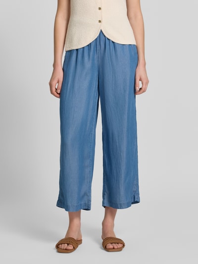 Frauenmodel trägt Wide Fit Stoffhose aus reinem Lyocell in Denim-Optik von Soyaconcept, verkürzte Passform, elastischer Bund mit Tunnelzug, Blauton, glatte Textur, Ganzkörperansicht von vorne.