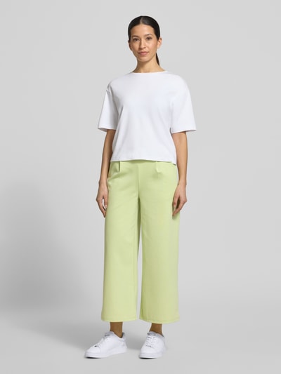 Frauenmodel trägt Wide Leg Sweatpants mit elastischem Bund Modell 'Kate' von ICHI, Material-Mix mit Viskose-Anteil in Hellgrün, Ganzkörperansicht von vorne.