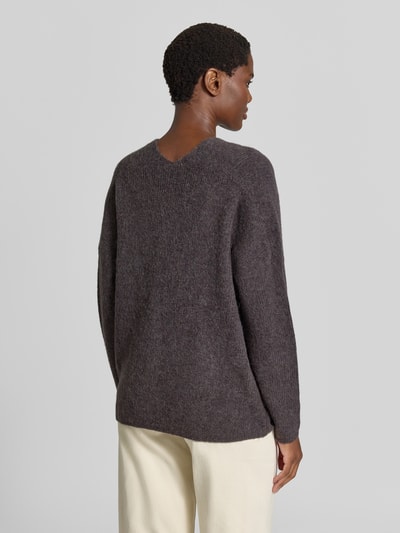 Männermodel trägt sweter z dzianiny z mieszanki wełny z domieszką alpaki, krój regular fit, dekolt w serek, model 'THORA' od MOS MOSH, kolor ciemnoszary, długość tyłu w rozmiarze S: 82 cm, długość rękawów w rozmiarze S: 46 cm, widok całej sylwetki z tyłu.