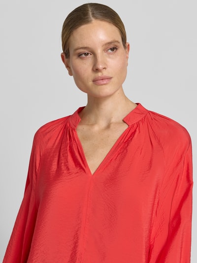Frauenmodel trägt Bluse aus Viskose-Mix mit Serafino-Ausschnitt von Christian Berg Woman in leuchtendem Rot, lockere Passform, Nahaufnahme Oberkörper.