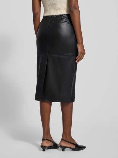 Vrouwenmodel draagt Midirok in leerlook van Calvin Klein Womenswear, los model, steekzakken, onderrok, totale lengte 76 cm, geheel achteraanzicht.