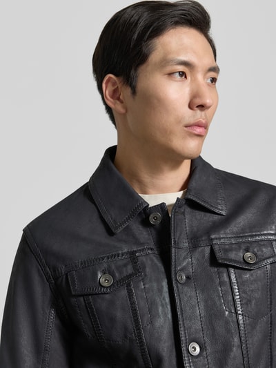 Männermodel trägt Lederjacke aus Schafsnubuk mit Brusttaschen Modell 'MEDDO' von MAURITIUS, Regular Fit, Umlegekragen, Knopfleiste, Nahaufnahme Oberkörper.