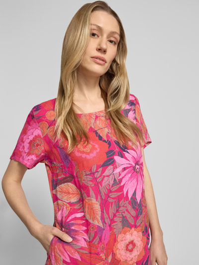 Frauenmodel trägt Knielanges Kleid aus Leinen-Mix Modell 'La44ra' von ZABAIONE im Allover-Look, leuchtende Pink- und Rottöne, Rundhalsausschnitt, Baumwoll-Anteil, florale Muster, Gerader-Schnitt, Nahaufnahme Oberkörper.