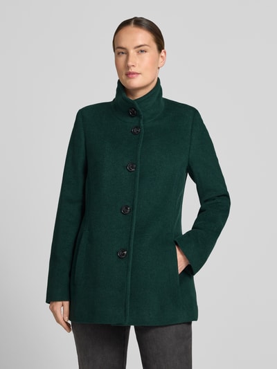 Modelka nosi Jacke mit Stehkragen und Eingrifftaschen von FUCHS SCHMITT, ciemnozielona, Mieszanka materiałów z dodatkiem wełny, Linia a, stójka, listwa guzikowa, wpuszczane kieszenie, Długość tyłu w rozmiarze 36: 73 cm, Szerokość ramion w rozmiarze 36: 37 cm, Szerokość w rozmiarze 36: 48 cm, Długość rękawów w rozmiarze 36: 64 cm, matowa tekstura, widoczne guziki, Ganzkörperansicht z przodu