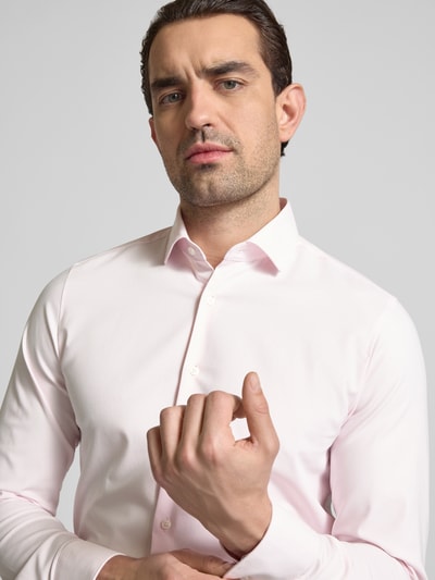 Männermodel trägt Slim Fit Business-Hemd mit Kentkragen von OLYMP Level Five im Baumwoll-Mix, Nahaufnahme Oberkörper, dezentes Rosa. Rückenlänge 78 cm, Schulterbreite 38 cm, Ärmellänge 68 cm bei Größe 40, Knopfleiste.