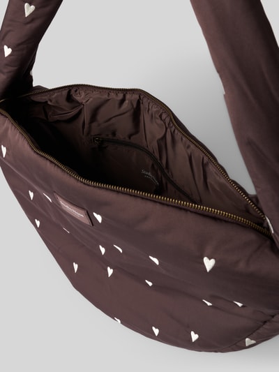 Produktfoto, Handtasche mit Stitchings und Label-Detail von STUDIO NOOS, braune Oberfläche mit weißen Herz-Stitchings, Hauptfach mit Reißverschluss, Label-Detail, Schulterriemen, Maße: Breite 50 cm, Länge 35 cm, Tiefe 11 cm, Schulterriemen 77 cm