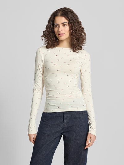 Frauenmodel trägt Longsleeve mit Viskose-Anteil von OH APRIL, Viskose-Elasthan-Mix, Körpernaher-Schnitt, U-Boot-Ausschnitt, Label-Stitching, Creme mit dezentem Muster, Rückenlänge bei Größe S: 110 cm, Ganzkörperansicht von vorne.