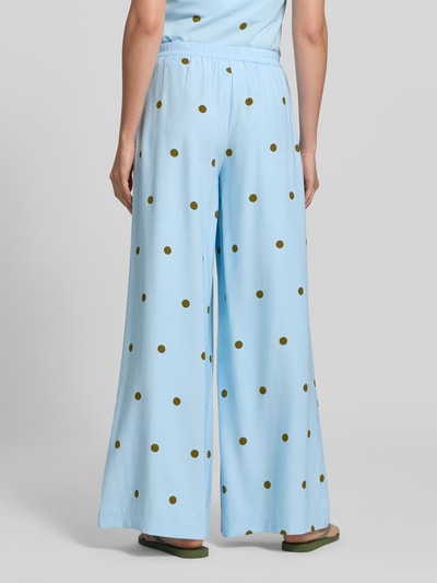 Frauenmodel trägt Fließende Hose mit weitem Bein - curated by Mary Braun von Style Icon Collection im Viskose-Mix, weite Beine, Elastikbund, hellblau mit braunen Punkten, Ganzkörperansicht Rückansicht.