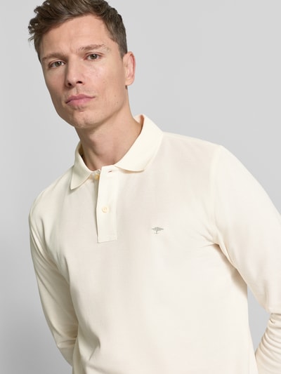 Männermodel trägt Poloshirt mit Label-Stitching von Fynch-Hatton in Creme, Reine Baumwolle, Regular-Fit, Nahaufnahme Oberkörper.