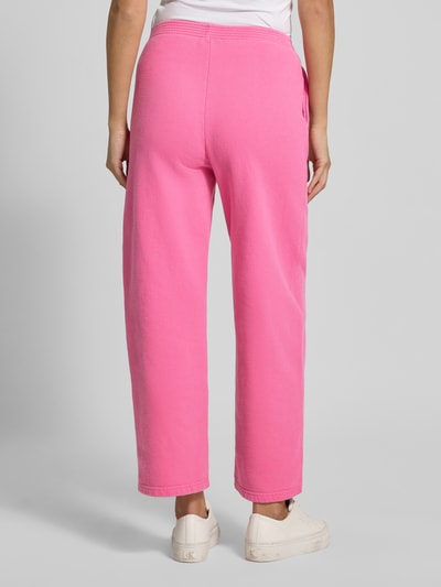 Vrouwenmodel draagt roze Sweatpants met Labelprint model 'PLIZZY' van American Vintage, puur katoen, relaxed fit, elastische band, binnenbeenlengte maat S 71 cm, volledige lichaamsweergave achteraan.