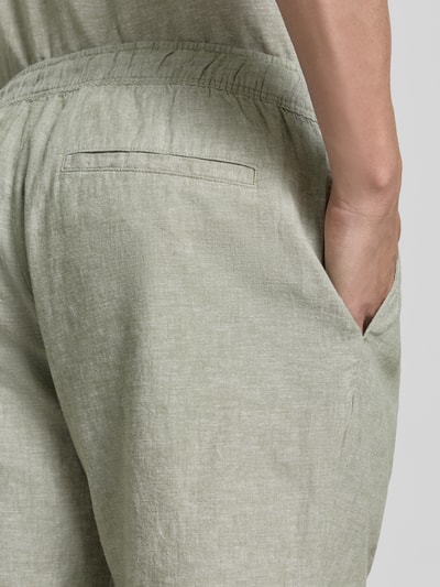 Männermodel trägt Shorts aus Leinen-Baumwoll-Mix mit elastischem Bund von MCNEAL, Regular-Fit, Tunnelzug, Detailaufnahme Rückenansicht.