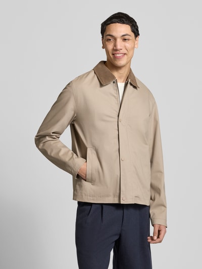 Męski model nosi Jacke mit Umlegekragen Modell 'GRAHAM' von Jack & Jones, krój regular fit, beż, zapięcie na guziki, widok całej sylwetki z przodu. Długość pleców w rozmiarze M: 67 cm, szerokość ramion w rozmiarze M: 40 cm, szerokość w rozmiarze M: 58 cm, długość rękawa w rozmiarze M: 73 cm.