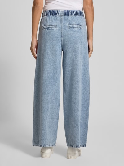 Frauenmodel trägt Wide Leg Jeans aus Baumwoll-Viskose-Mix Modell 'VALERIA' von Vero Moda in hellblauem Denim mit elastischem Bund und seitlichen Eingrifftaschen, Ganzkörperansicht Rückansicht.