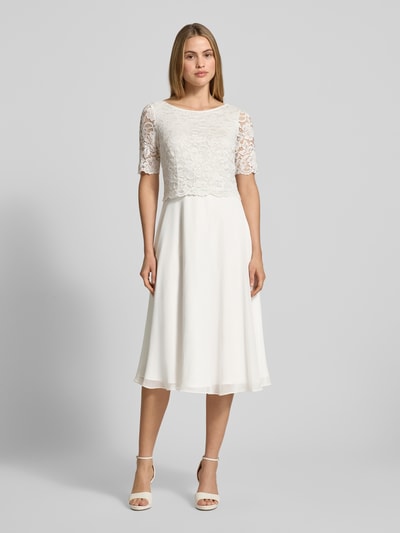 Vrouwenmodel draagt Cocktailjurk met kant en ronde hals van Vera Mont, chiffon, A-lijn, knielengte, 1/2-mouwen, voorkant, geheelfiguur.