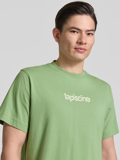 Männermodel trägt Regular Fit T-Shirt aus reiner Baumwolle Modell 'HASPEN' von SELECTED HOMME, Optik: Unifarben, Applikation: Schriftzug, Rundhals, Kurzarm, Nahaufnahme Oberkörper.