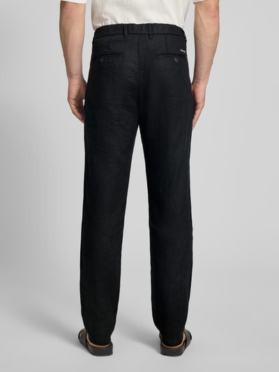 Männermodel trägt Tapered Leinenhose mit Gürtelschlaufen Modell 'OSBY JOGGER' von Marc O'Polo, Optik: Unifarben, Passform: Tapered, Bundfalte, Seitliche Eingrifftaschen, Gesäßtaschen, Verschluss: Knopf und Reißverschluss, Material: Leinen, Ganzkörperansicht Rückansicht.