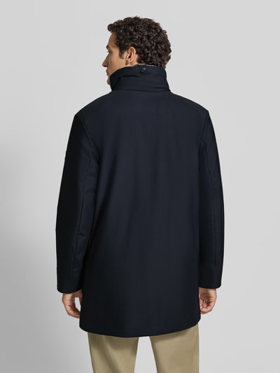 Männermodel trägt Regular Fit Parka mit abnehmbarem Kunstfellbesatz Modell 'Flex' von Strellson in Dunkelblau, Ganzkörperansicht Rückansicht. Herren Parka von Strellson.