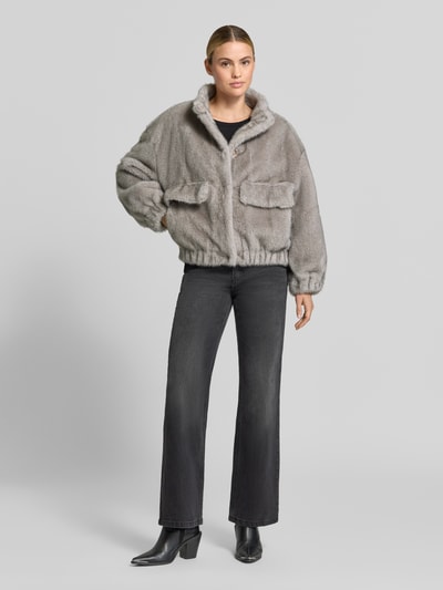 Kobiece model nosi Regular Fit Jacke aus Kunstfell Modell 'GIACCONE' od Liu Jo White, szare sztuczne futro, stójka, kieszenie z patką, elastyczne wykończenia, długość tyłu w rozmiarze 36: 59 cm, szerokość ramion w rozmiarze 36: 56 cm, szerokość w rozmiarze 36: 60 cm, długość rękawów w rozmiarze 36: 50 cm, widok całej sylwetki z przodu.