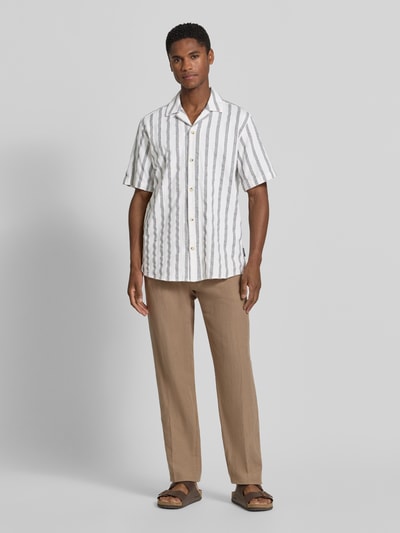 Männermodel trägt Regular Fit Freizeithemd aus reiner Baumwolle von Tom Tailor, Streifenmuster, helle Farben, Ganzkörperansicht von vorne.