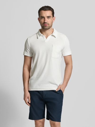Männermodel trägt Relaxed Fit Poloshirt mit V-Ausschnitt von Lindbergh aus Baumwoll-Mix in Frottee mit Brusttasche, Ganzkörperansicht von vorne.