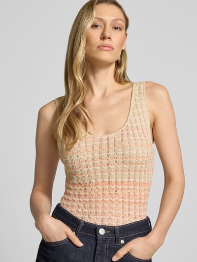 Modelka nosi top z dzianiny z mieszanki wiskozy o dopasowanym kroju model 'ROSALYN' od Guess, okrągły dekolt, detal z logo, pastelowe kolory, długość tyłu w rozmiarze S: 41 cm, damski, zbliżenie na górną część sylwetki z przodu.