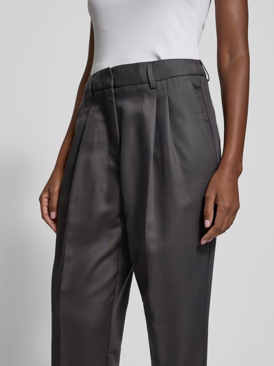 Frauenmodel trägt Stoffhose mit Gesäßtaschen von black palms, Lyocell-Mix mit Baumwoll-Anteil, lockerer Schnitt, Bundfalten, Nahaufnahme Oberkörper