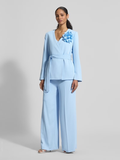 Frauenmodel trägt Wide Fit Stoffhose mit Bügelfalten von Christian Berg Cocktail in Hellblau, mit Gesäßtaschen und Haken- und Reißverschluss, Ganzkörperansicht von vorne.