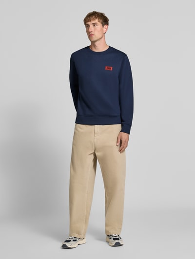 Männermodel trägt donkerblauw sweatshirt met labelprint, katoenmix, los model, ronde hals, ribboorden, Model 'RUSH' van JACK & JONES, ruglengte 67 cm, mouwlengte 67 cm, Ganzkörperansicht von vorne