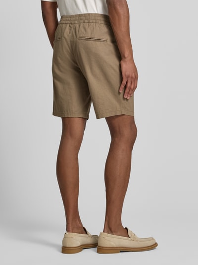 Mannenmodel draagt Shorts uit mix van katoen en linnen Model 'barton' van Matinique, regular fit, elastische band met tunnelkoord, bandwijdte maat M 43 cm, binnenbeenlengte maat M 21 cm, kleur lichtbruin, structuur met zichtbare weving, effen, rechte pasvorm, achterzakken, geheellichaamsaanzicht achteraan.