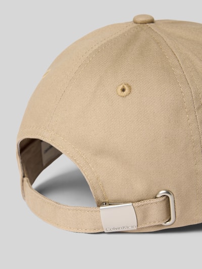 Produktfoto, beiger Baumwollstoff, größenverstellbare Cap mit Label-Stitching von CK Calvin Klein, verstärkter Schirm, silberne Schnalle