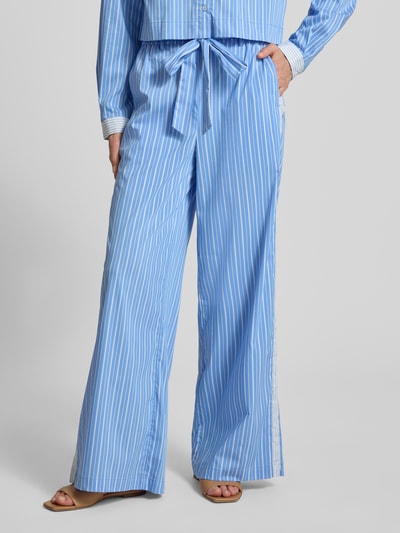 Frauenmodel trägt Wide Leg Pants mit Bindegürtel Modell 'Dana' von GUIDO MARIA KRETSCHMER WOMAN aus hellblau-weiß gestreiftem Baumwoll-Mix, ausgestellter Schnitt, elastischer Bund, französische Eingrifftaschen, Nahaufnahme Unterkörper.