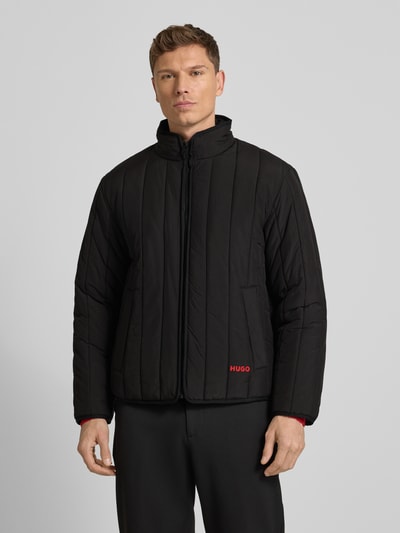 Männermodel trägt Regular Fit Steppjacke mit Stehkragen Modell 'BRENOTO' von HUGO, Optik: Unifarben, Ganzkörperansicht von vorne.