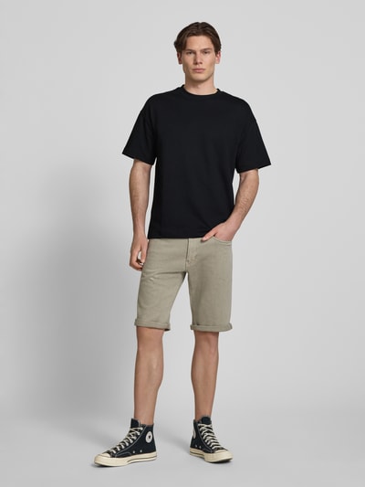 Mannenmodel draagt T-shirt met ronde hals model 'BARRON' van Jack & Jones, katoenmix met stretch, regular fit, ruglengte maat M 69 cm, effen zwart, gladde structuur, recht model. Volledige lichaamsopname van voren.