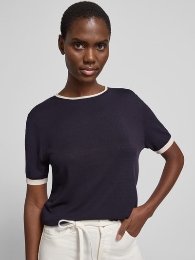 Frauenmodel trägt Strickshirt mit Rundhalsausschnitt von comma, dunkelblauer Viskose-Mix mit Kontraststreifen, Slim Fit, Nahaufnahme Oberkörper.