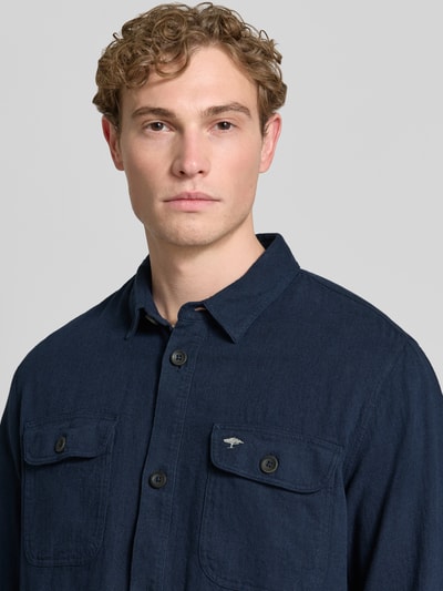 Männermodel trägt Regular Fit Hemdjacke aus Leinen-Baumwoll-Mix mit Kentkragen von Fynch-Hatton, Label-Stitching, Nahaufnahme Oberkörper. Rückenlänge bei Größe M: 80 cm, dunkle Farbe, Brusttaschen, strukturierte Oberfläche.
